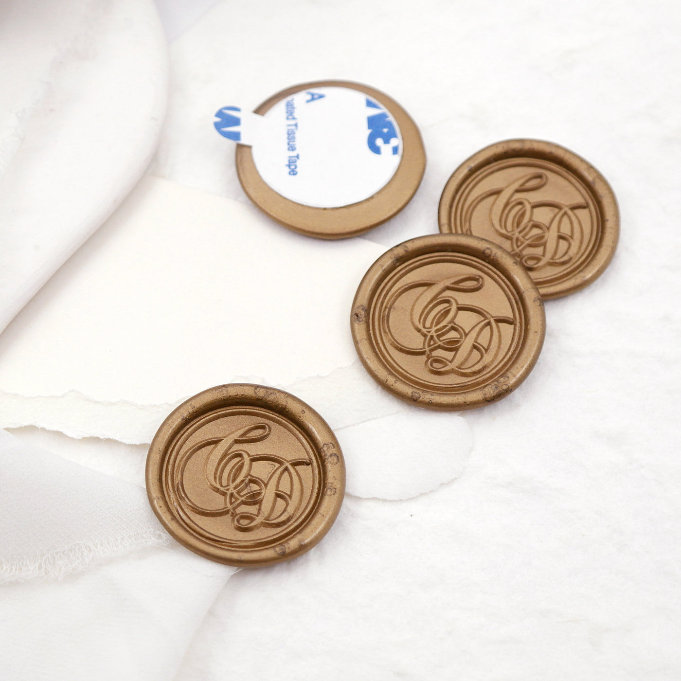 Four wax seals on the table, three wax seals with calligraphy alphabets , and other is the back with sticker